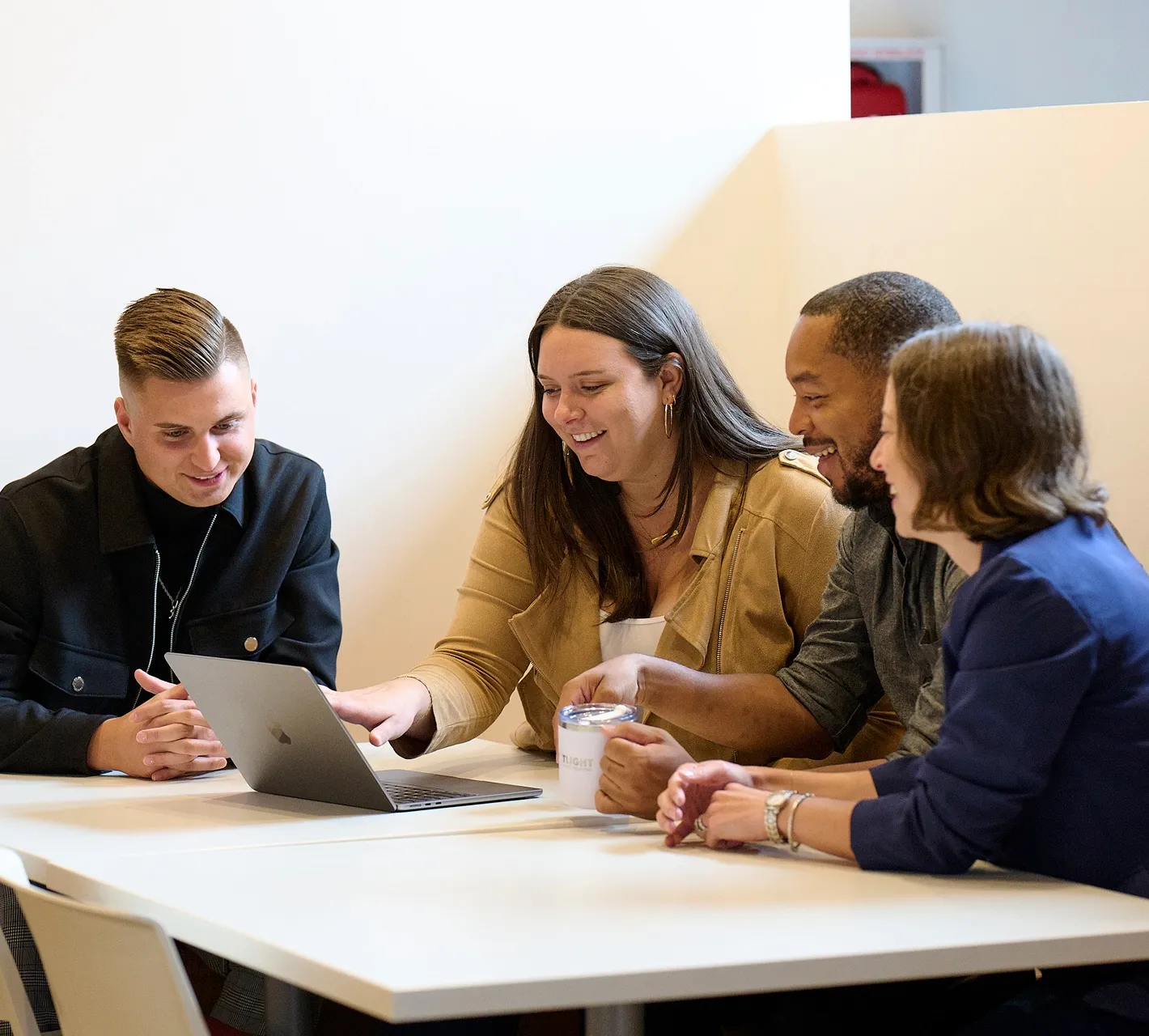 Team members collaborating around a laptop